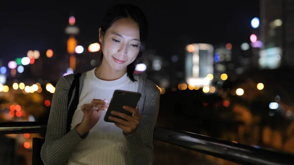 Vrouw die 's nachts smartphone gebruikt — Stockfoto