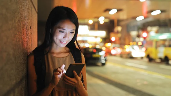 Kvinna tittar på mobiltelefon — Stockfoto