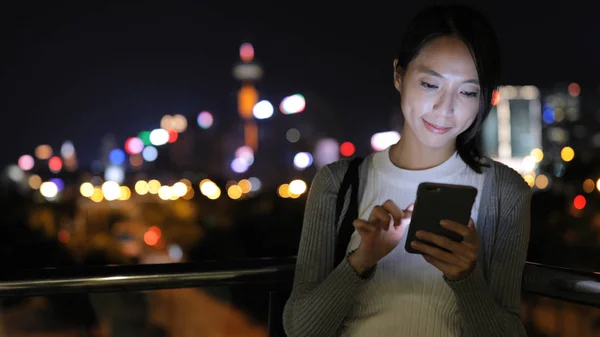 Mulher enviando SMS no celular à noite — Fotografia de Stock