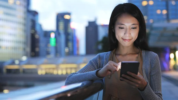 Mulher usando smartphone à noite — Fotografia de Stock