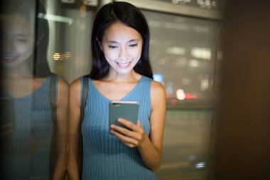 Geceleri cep telefonu kullanan bir kadın.