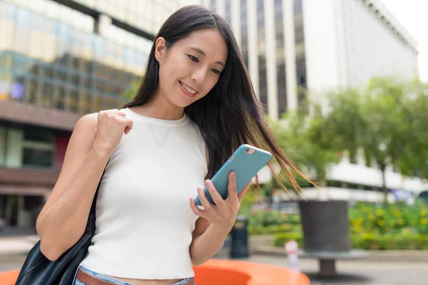 Şehirde akıllı telefon kullanan bir iş kadını.