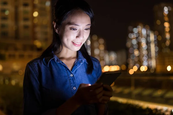 Mulher trabalhando no smartphone à noite — Fotografia de Stock