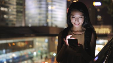 Geceleri cep telefonu kullanan kadın