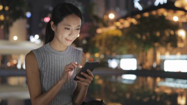 Akıllı telefon kullanan genç bir kadın. 