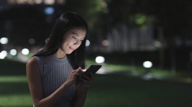 Şehirde akıllı telefon kullanan bir kadın