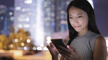 Şehirde Smartphone kullanan genç kadın 