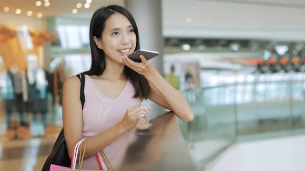 Nő a gazdaság bevásárló táskák, és használja a mobilját — Stock Fotó