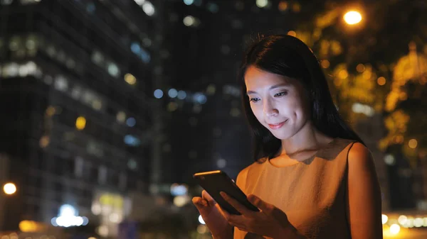 Jovem mulher usando smartphone à noite — Fotografia de Stock