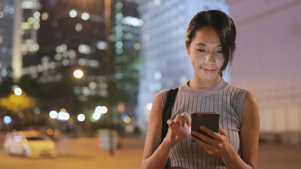 Mulher usando telefone celular à noite — Fotografia de Stock