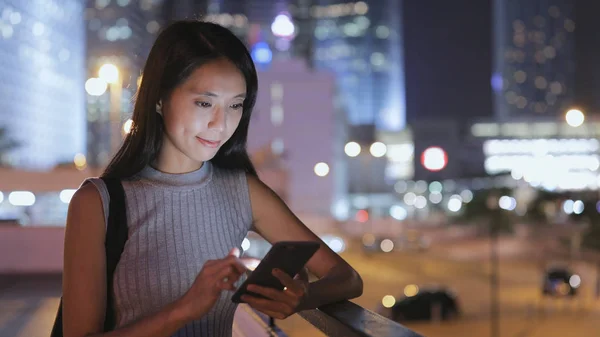 Mujer leyendo en el celular por la noche —  Fotos de Stock