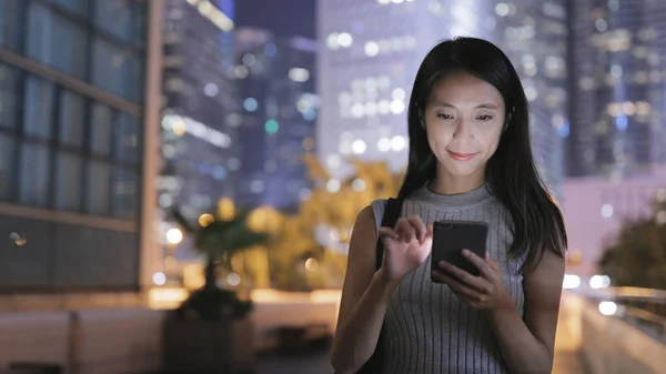 Mulher usando telefone celular à noite — Fotografia de Stock