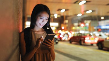 Akıllı telefon kullanan genç bir kadın.