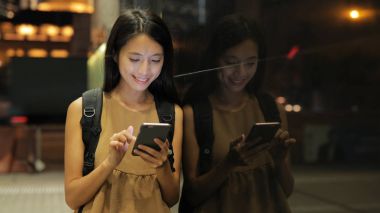 Kadın cep telefonuna bakıyor.