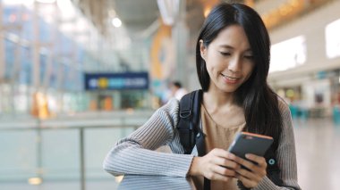 İstasyonda cep telefonu kullanan kadın