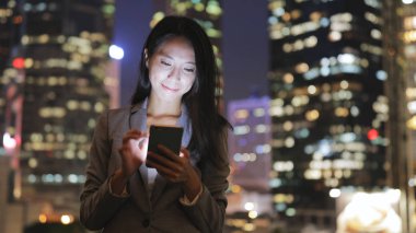 Geceleri cep telefonu kullanarak iş kadını 