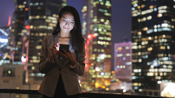Businesswoman using cellphone at night 