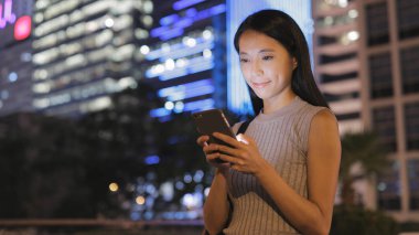 Kadın cep telefonuna bakıyor. 