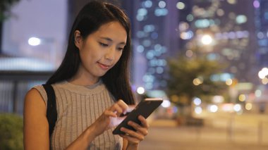 Geceleri cep telefonu kullanan kadın 