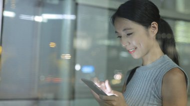 Gece akıllı telefon kullanan bir kadın.