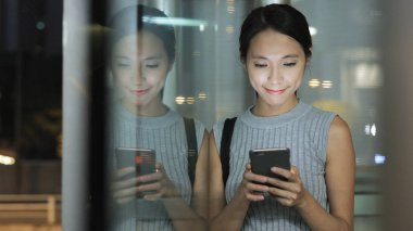 Geceleri cep telefonu kullanan bir kadın. 