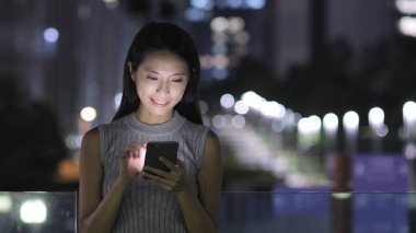 Akıllı telefon kullanan genç bir kadın. 