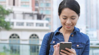 Şehirde akıllı telefon kullanan bir kadın 