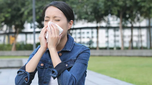 Young Woman sneeze in city