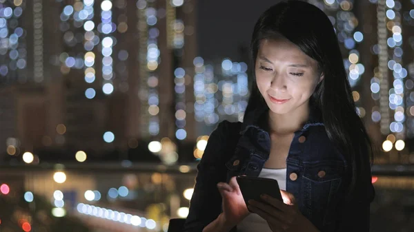 Mulher usando celular à noite — Fotografia de Stock