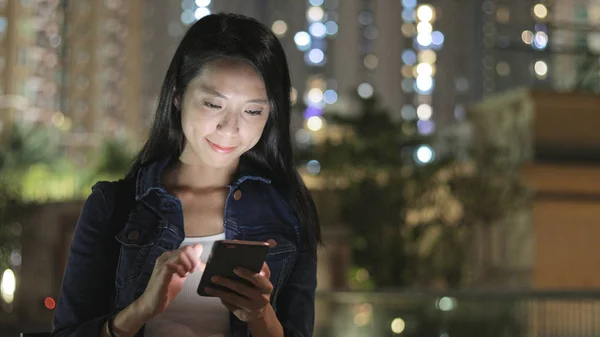 Mulher enviando SMS no celular à noite — Fotografia de Stock