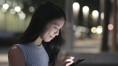 Geceleri cep telefonu kullanan kadın 