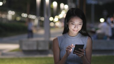 Geceleri cep telefonu kullanan kadın 