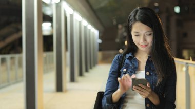 Geceleri smartphone üzerinde çalışan kadın 