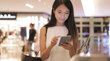 alışveriş merkezinde cep telefonu kullanan kadın 