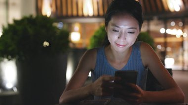 Kadın şehirde cep telefonu kullanıyor. 