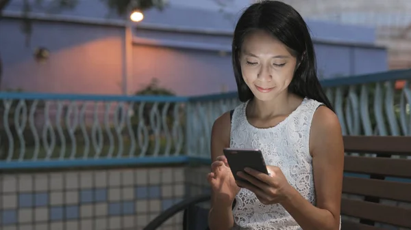 Žena pozoruje na mobil v noci — Stock fotografie