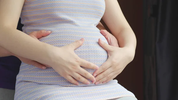 Pappa en mamma handen op zwangere buik — Stockfoto