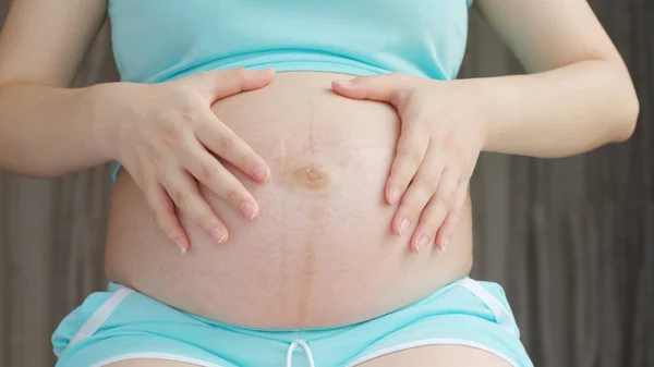 Massage van de zwangere vrouw op haar buik — Stockfoto