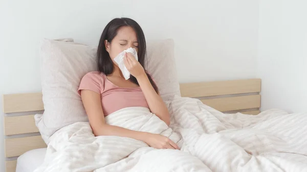 Mujer enfermándose y estornudando en la cama — Foto de Stock