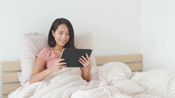 Vrouw met behulp van tablet pc op bed — Stockfoto