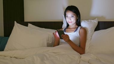 Evde akıllı telefon kullanan bir kadın. 