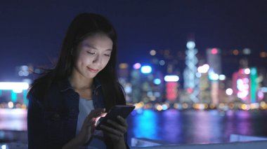 Geceleri cep telefonu kullanan bir kadın. 