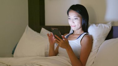 Geceleri cep telefonu kullanan bir kadın. 