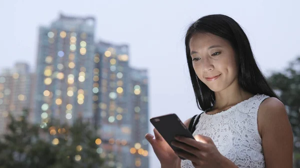 Vrouw met smartphone in de stad — Stockfoto