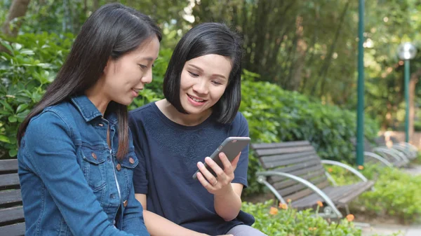 公園で携帯電話を使用しての友人 — ストック写真