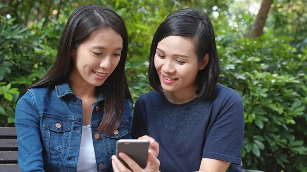 Cep telefonu ile parkta konuşan arkadaşlar 