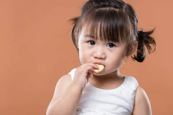 かわいい女の子のクッキーを食べて — ストック写真