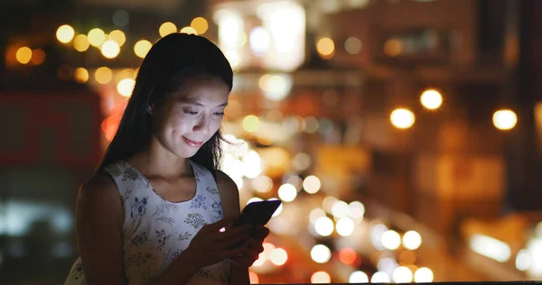 Woman using mobile phone at night