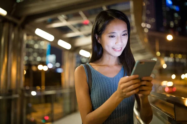 Mujer enviando SMS en el teléfono inteligente por la noche — Foto de Stock