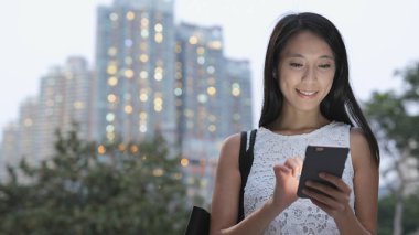 Cityscape içinde smartphone kullanan kadın 